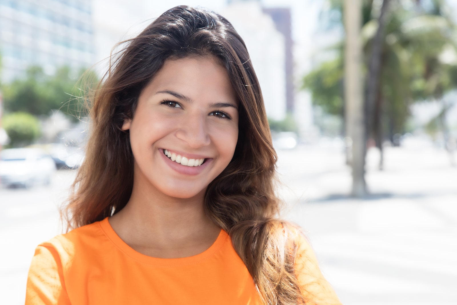 Beautiful caucasian woman in a orange shirt in the city